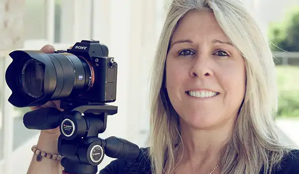 Sue Tatterson smiling and holding a camera
