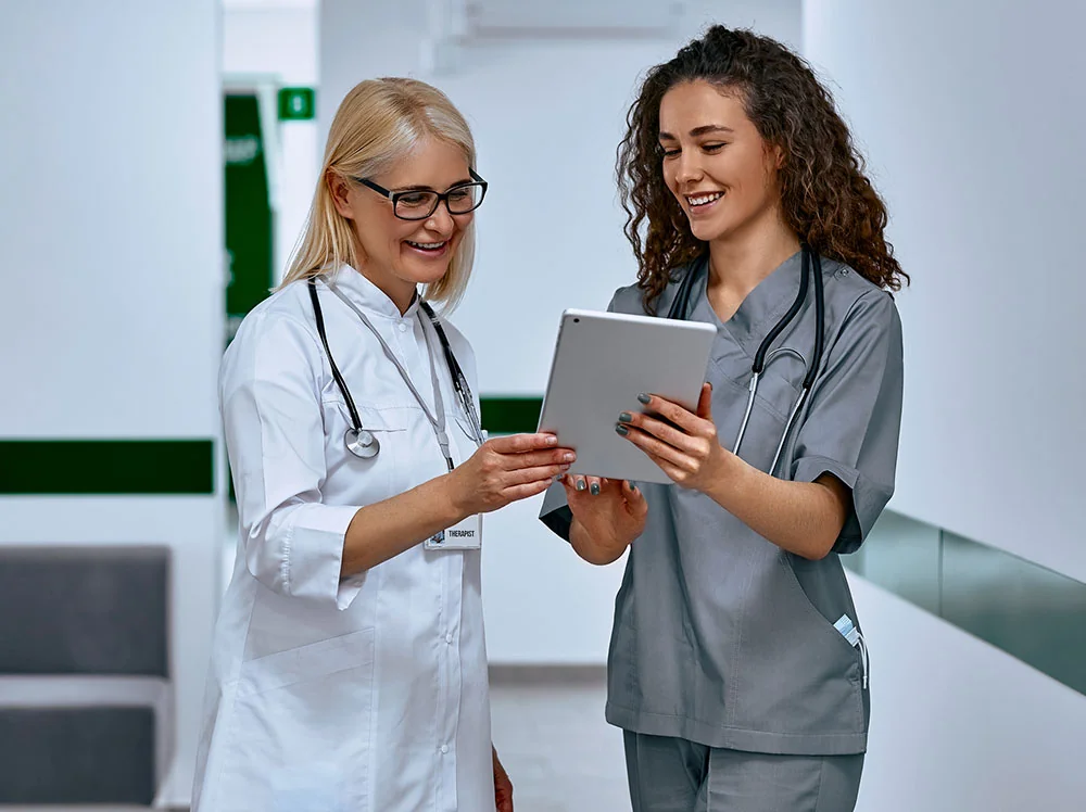 Physician assistant talking to the doctor with an iPad