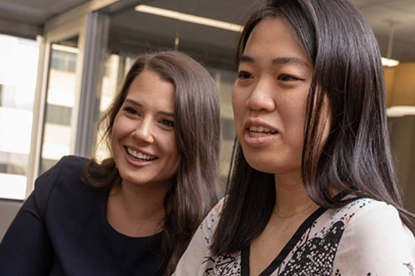 Two women studying something out of frame