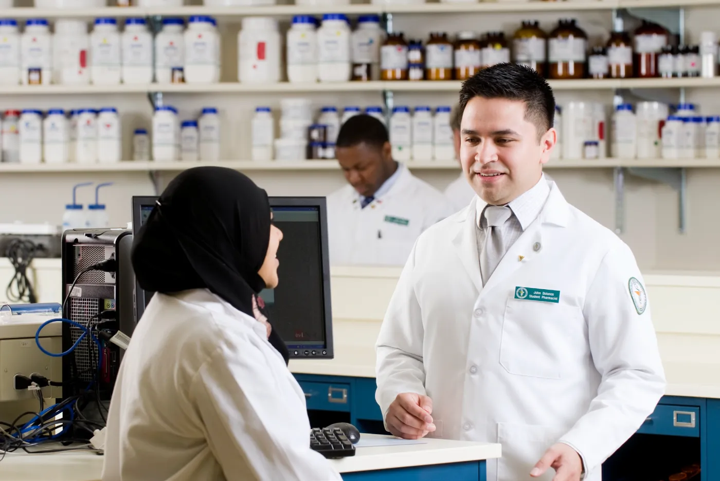 Chicago State University student pharmacists working together in a pharmacy lab setting.