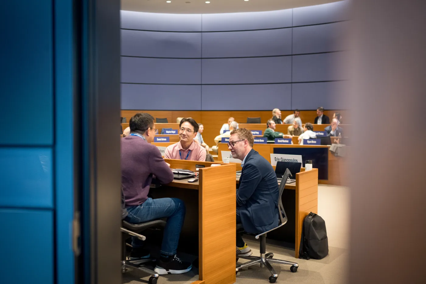 Men in suits having discussion in a classroom